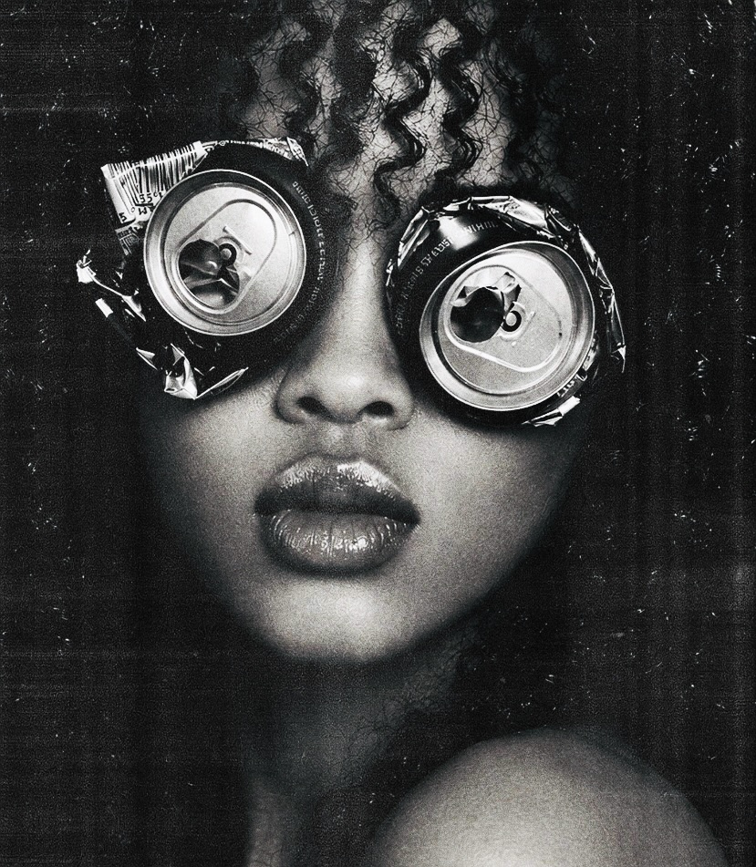 A black and white portrait of a woman wearing crushed soda cans over her eyes like goggles, glossed lips.
